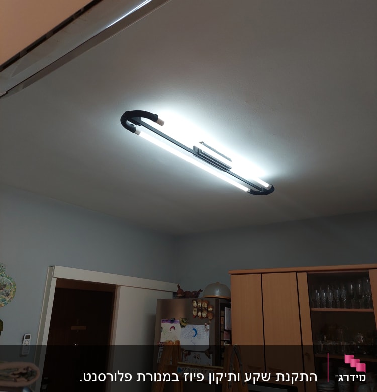 תאורת פלורסנט מותקנת על תקרה עם סולם עץ מתחתיה